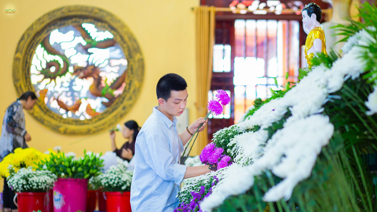 Bạn trẻ khéo léo cắm những đóa hoa tươi thắm, tạo khối hình hoa 3D rực rỡ tại ban Tam Bảo