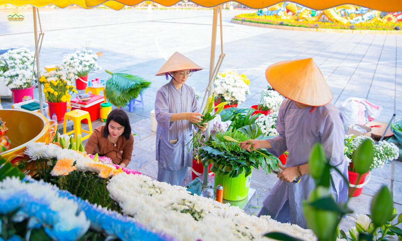 Các Phật tử cẩn thận cắm từng đóa hoa tươi để góp phần vào sự rực rỡ đón mừng Khánh đản