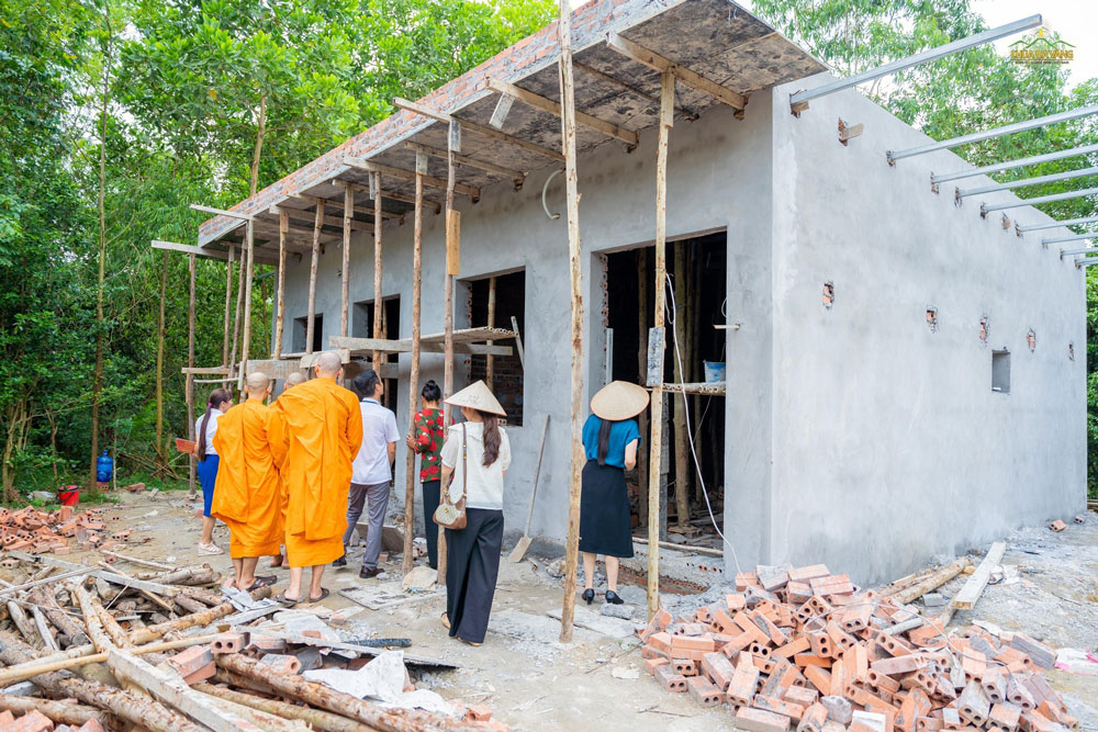 Đoàn tham quan ngôi nhà đang được xây dựng.  