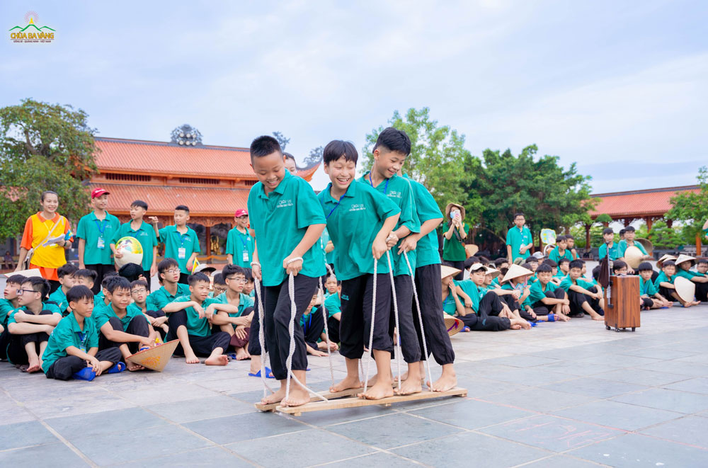 Tình bạn thêm gắn kết khi các bạn cùng vượt qua trò chơi đi hia gỗ.  