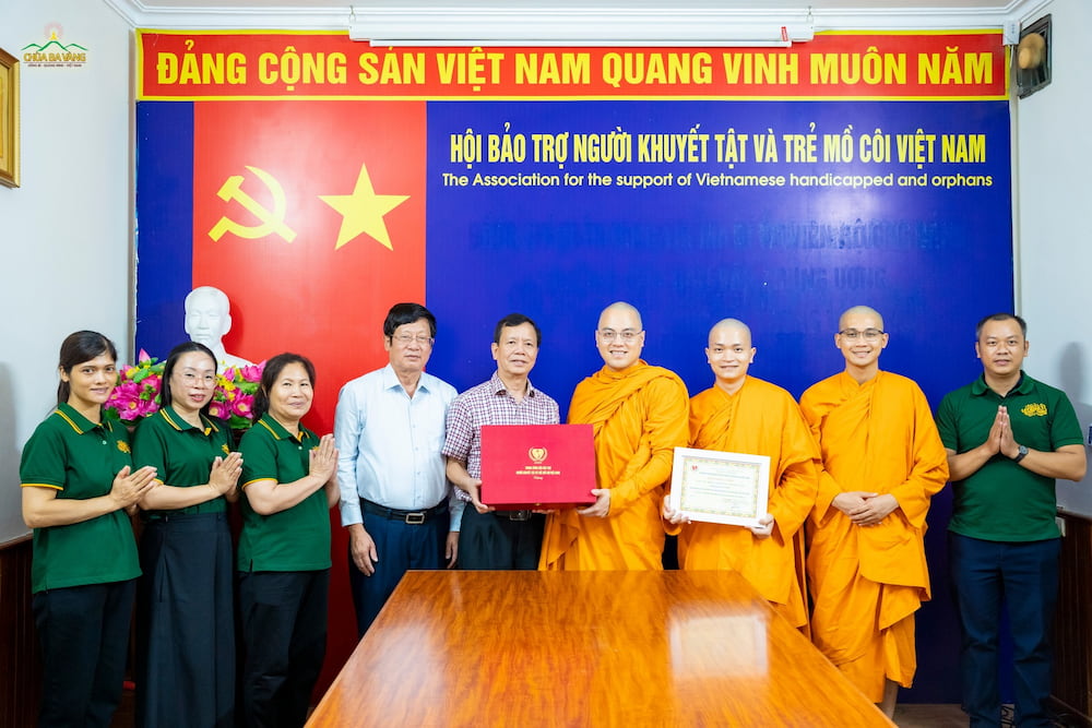 Ông Nguyễn Trọng Đàm - Chủ tịch Hội Bảo trợ người khuyết tật và trẻ mồ côi Việt Nam, Nguyên Thứ trưởng Bộ Lao động Thương binh và Xã hội (áo kẻ sơ mi) đại diện Hội trao quà và thư cảm ơn chư Tăng, Phật tử chùa Ba Vàng.