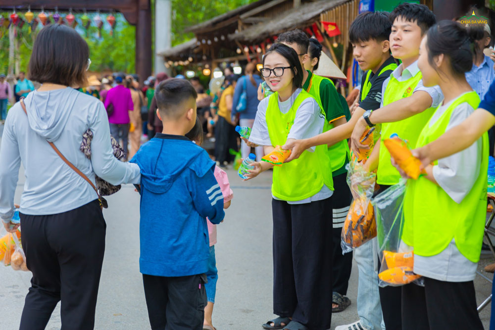 Các bạn trong CLB Tuổi Trẻ trao gửi những chiếc bánh mì và nước uống tới Nhân dân, du khách đi chiêm bái Xá lợi Phật