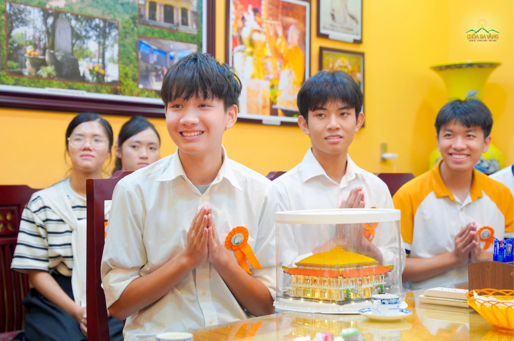 Quang Vinh và Hải Nam (2 khóa sinh mặc áo sơ mi trắng) thành kính bạch cúng dường Sư Phụ mô hình