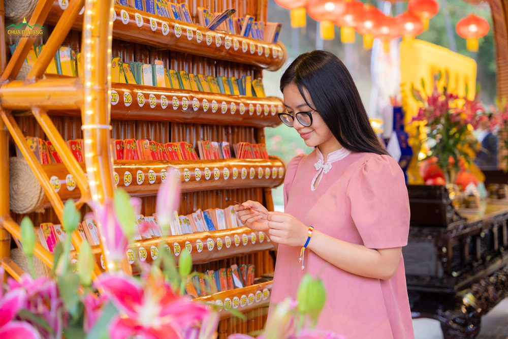 Bạn trẻ chăm chú đọc lời Phật dạy đầu năm trên thẻ lộc xuân