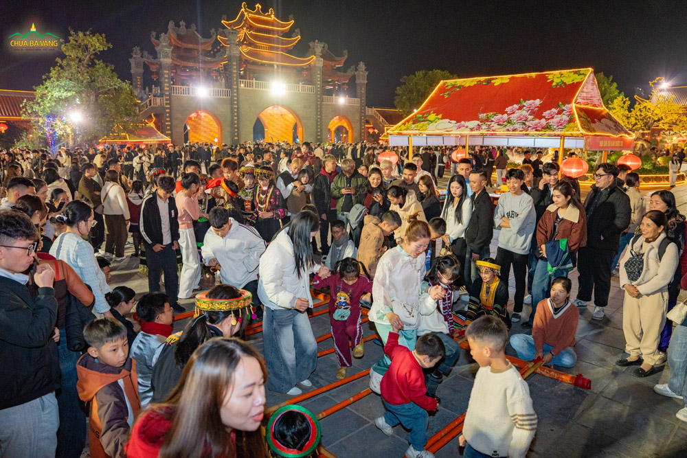 Trong nhịp tre vang đều, các du khách hào hứng hòa mình vào điệu nhảy sạp, rộn ràng tiếng cười làm nên bầu không khí mùa xuân tươi vui trên sân chùa