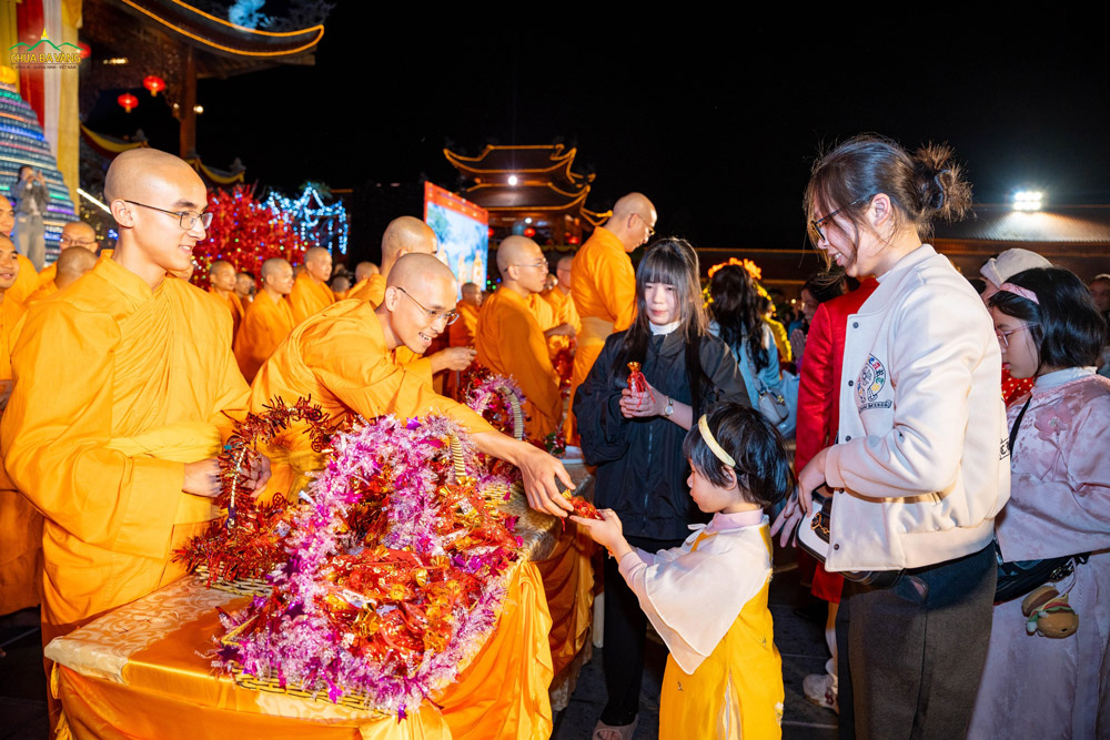 Các em nhỏ cung kính đón nhận túi lộc từ chư Tăng