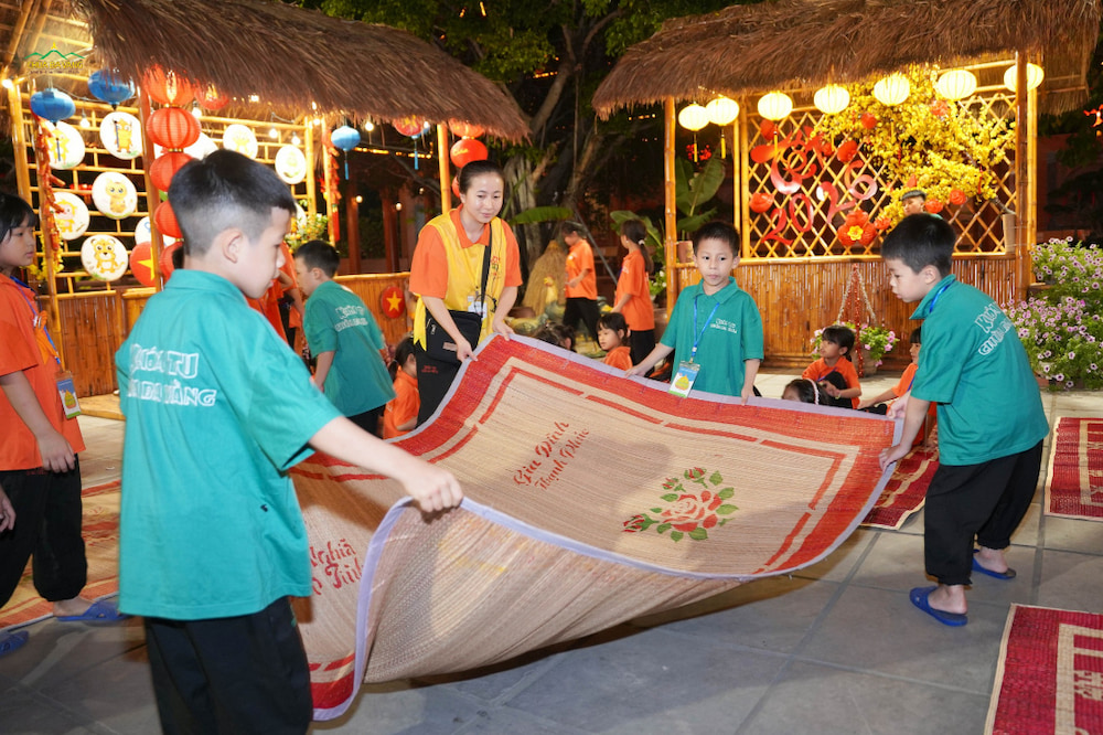 Các bạn khóa sinh giúp chị tình nguyện viên chuẩn bị đạo cụ cho khu trò chơi dân gian