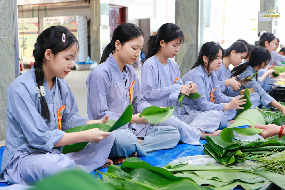 Sự tỉ mỉ và khéo léo của các bạn nữ trong khâu cắt, tỉa lá dong sao cho thật vừa vặn