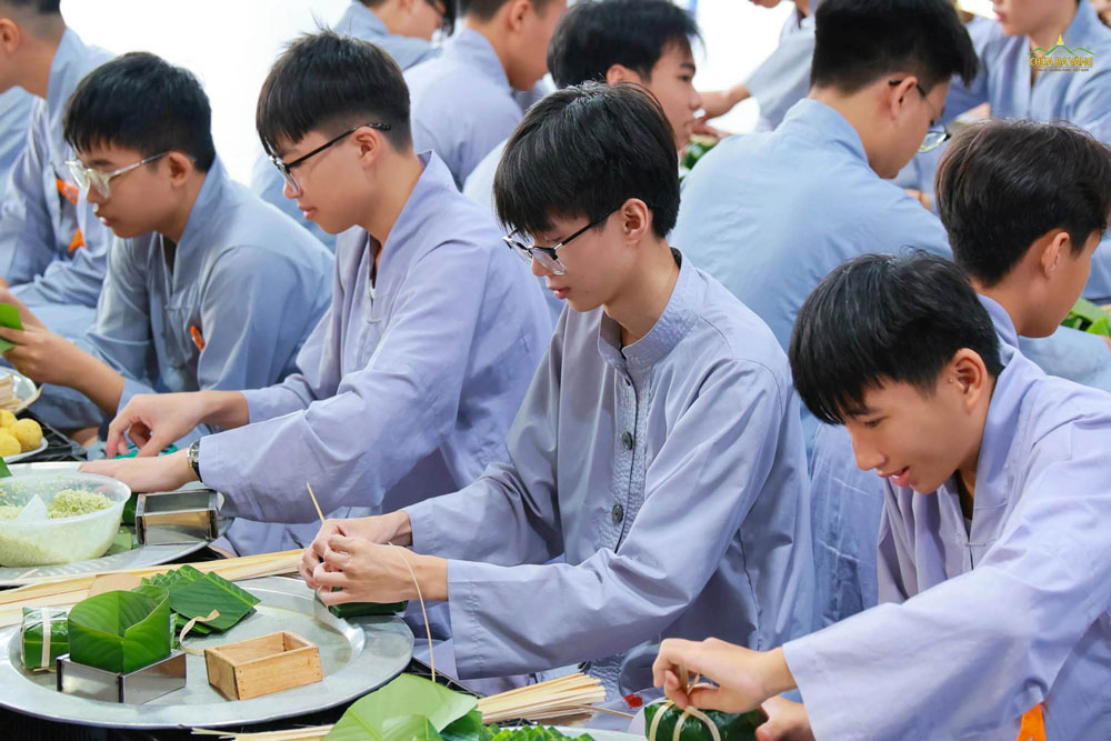 Các bạn nam khéo léo buộc những chiếc lạt cho bánh chưng