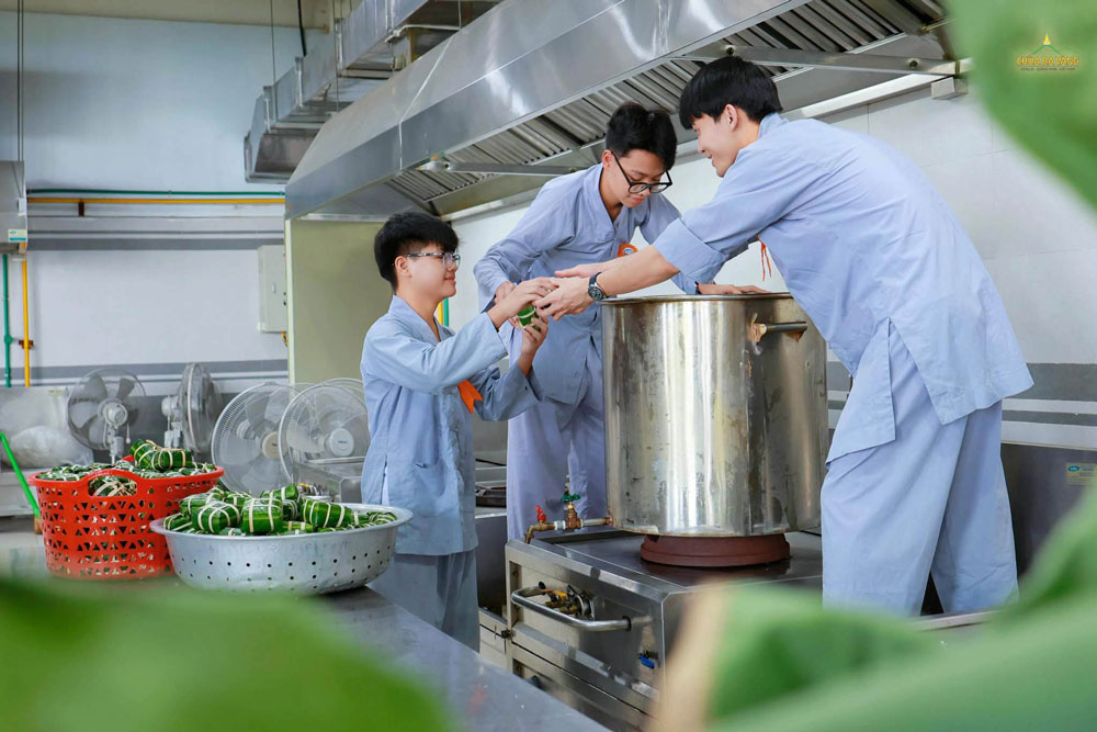 Các bạn khóa sinh hỗ trợ nhau xếp bánh chưng vào nồi để luộc