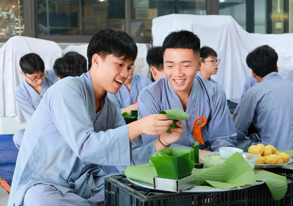 Các bạn khóa sinh chỉ nhau từng chút một, người biết trước hướng dẫn người biết sau để cùng gói chiếc bánh thật đẹp