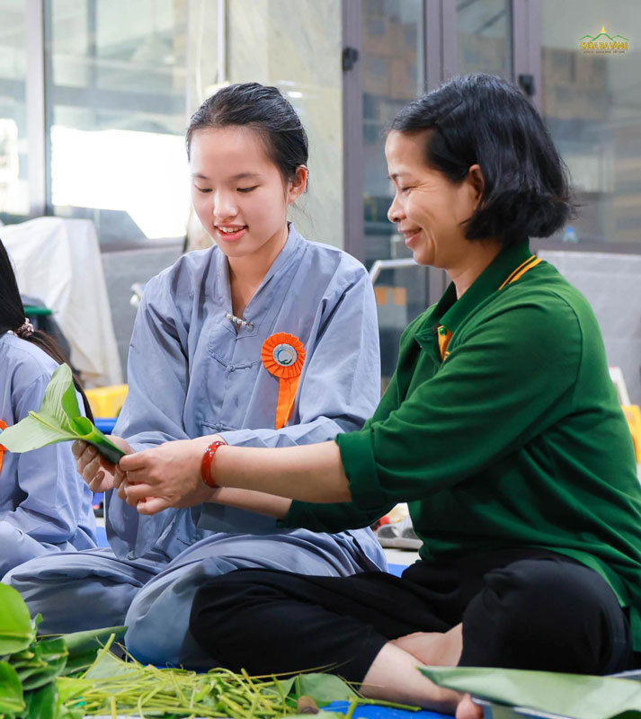 Cô Phật tử hướng dẫn bạn khoá sinh gấp lá dong