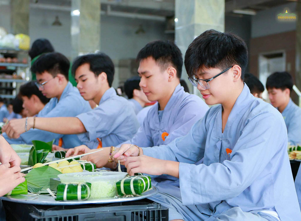 Không chỉ năng nổ, các bạn nam còn cực kỳ kiên trì và chắc tay trong khâu buộc lạt cho bánh
