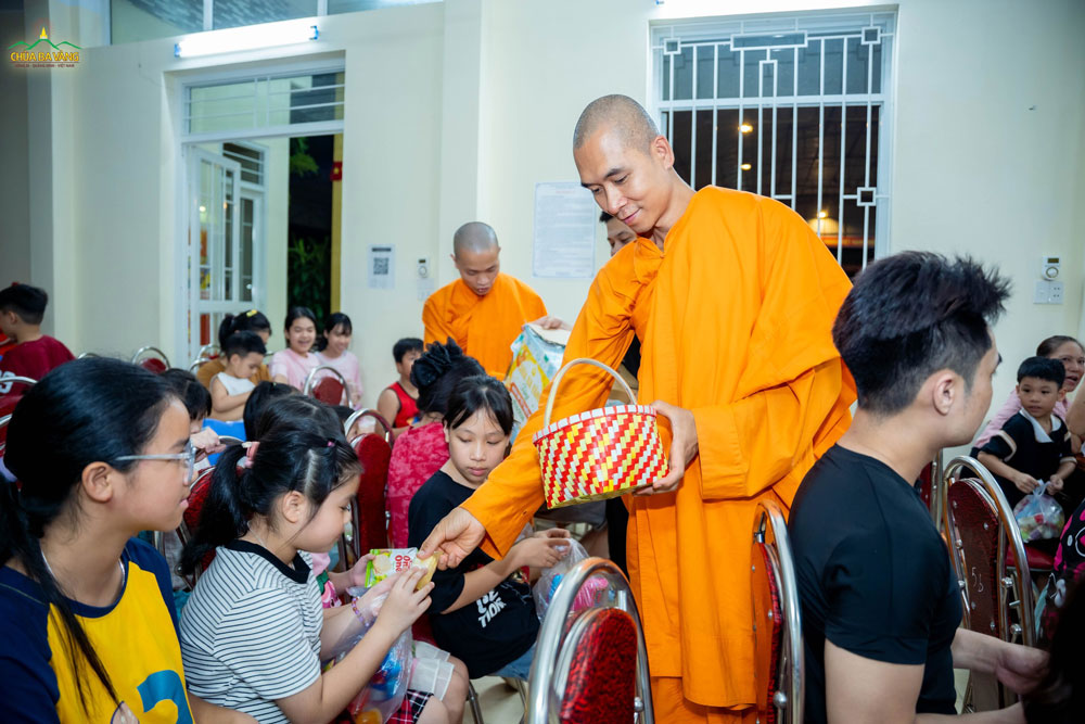 Em bé cung kính nhận quà từ chư Tăng