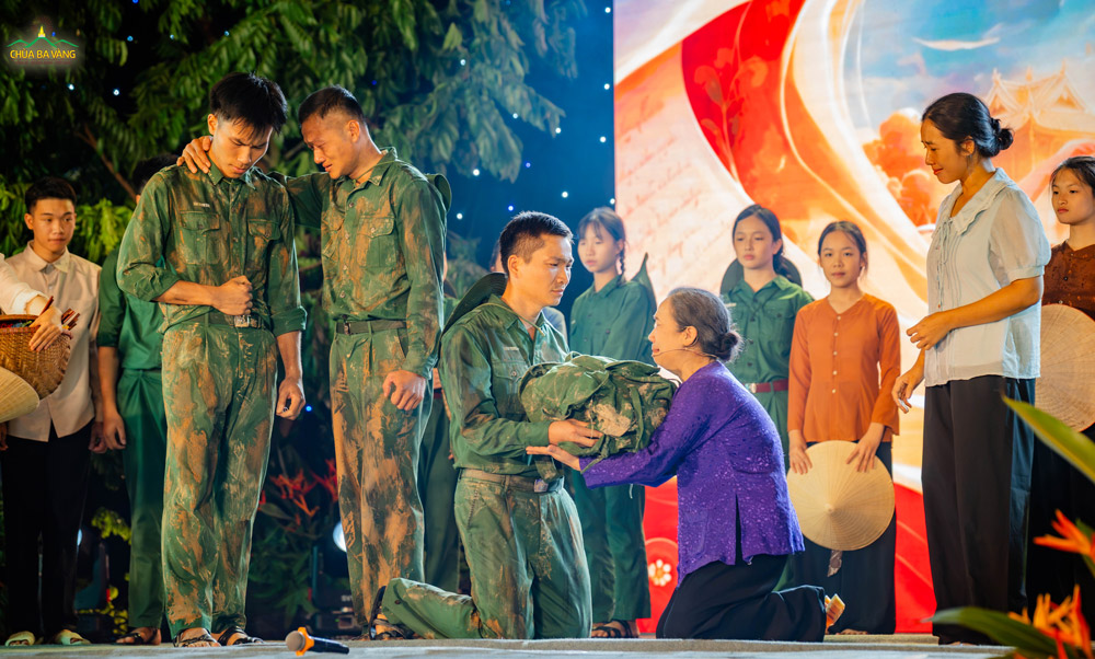 Đằng sau vinh quang của ngày hòa bình là sự hy sinh thầm lặng của những người mẹ. Giữa tiếng reo hò của ngày toàn thắng, vở hoạt kịch đã đem đến một nốt trầm nghẹn ngào: Khoảnh khắc người mẹ nhận lại chiếc ba lô của người con trai, ôm chặt kỷ vật của con vào lòng và vỡ òa trong dòng nước mắt.