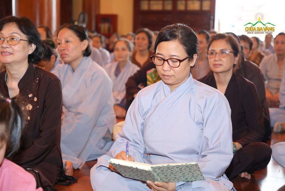 Các Phật tử chăm chú lắng nghe và ghi lại những lời giảng từ Sư Phụ 