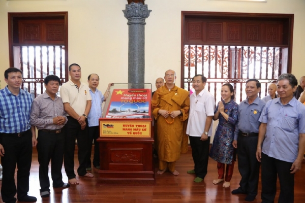 Thầy Thích Trúc Thái Minh chụp ảnh lưu niệm cùng với các đại biểu bên cạnh pho đại sách.