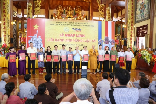Thầy Thích Trúc Thái Minh và Tiến sĩ Đoàn Mạnh Phương trao quà cho các Phật tử.