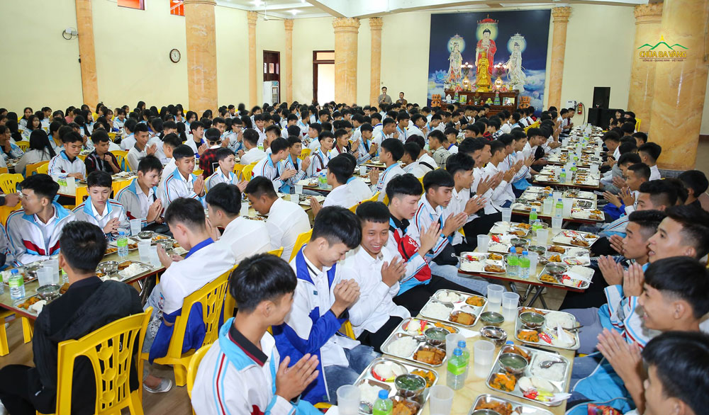 Các bạn học sinh thực hiện nghi thức cúng cơm trước khi ăn tại chùa 