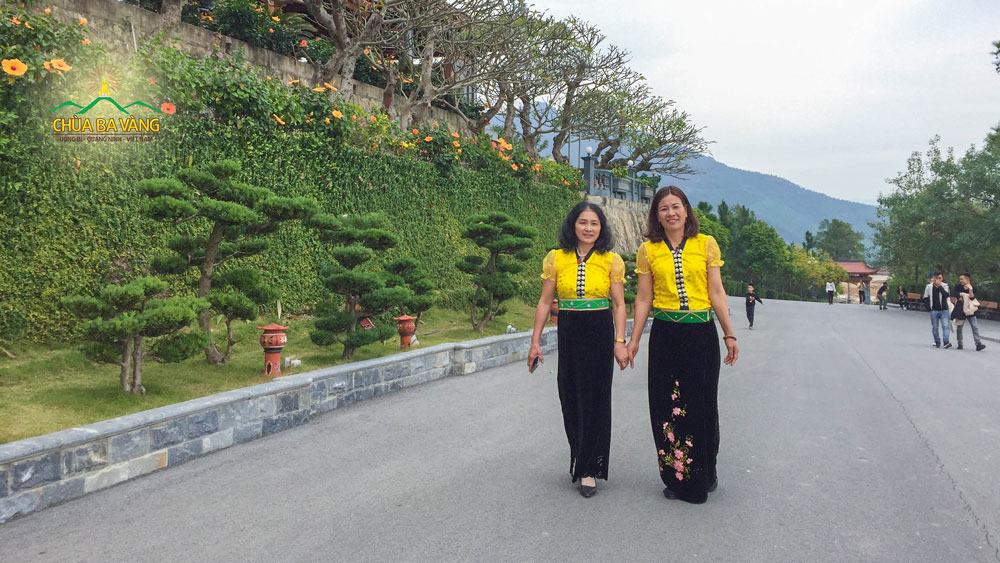 Cô Bùi Thị Hòa (bên phải) rạng rỡ trong trang phục quần áo dân tộc tại chùa