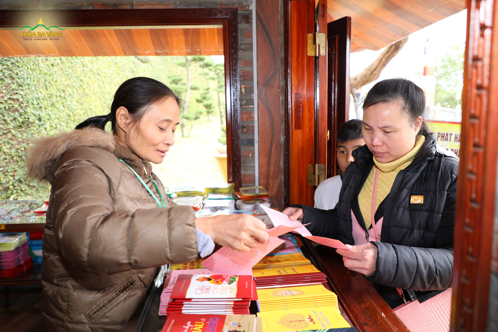 Phật tử tại quán phát hành kinh sách đang hướng dẫn khách