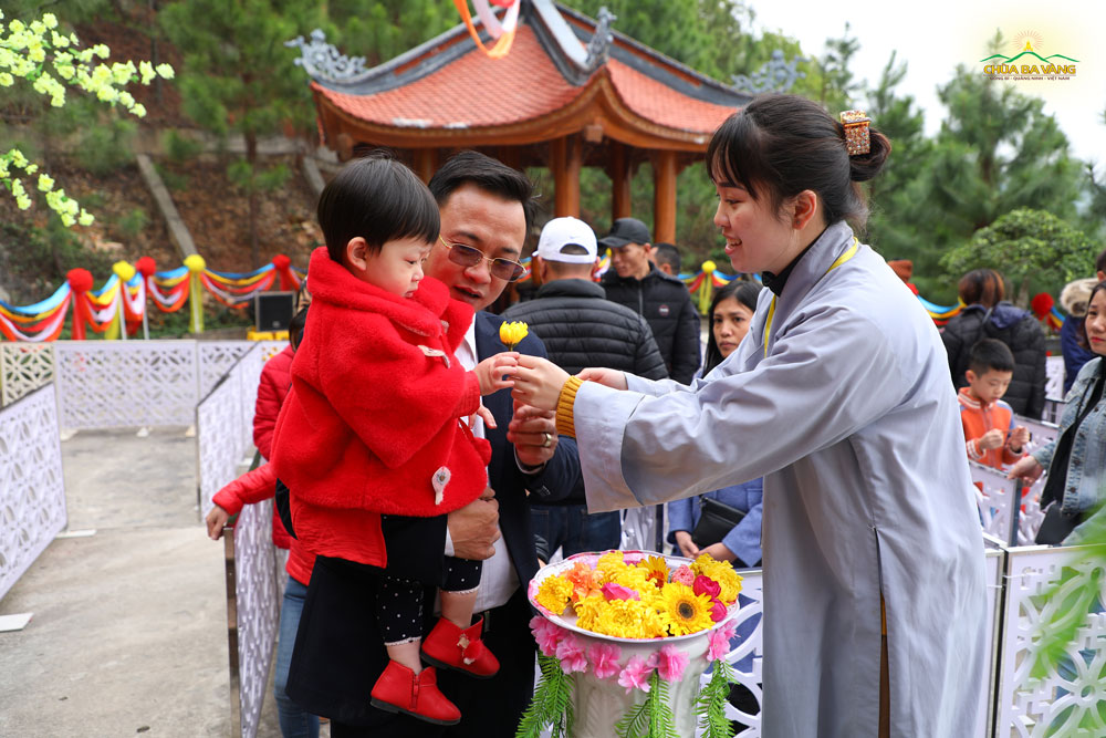 Phật tử trao hoa cho em nhỏ dâng lên cúng dường Xá Lợi Phật