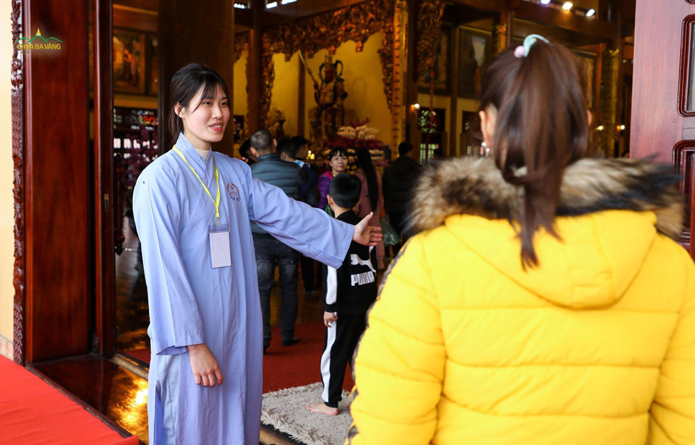 Phật tử trong ban Hương đăng hướng dẫn khách khi vào trong Chính điện