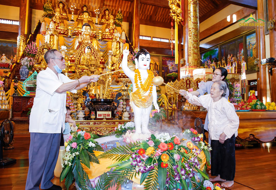 Thân phụ và thân mẫu của Sư Phụ thực hiện nghi lễ tắm Phật