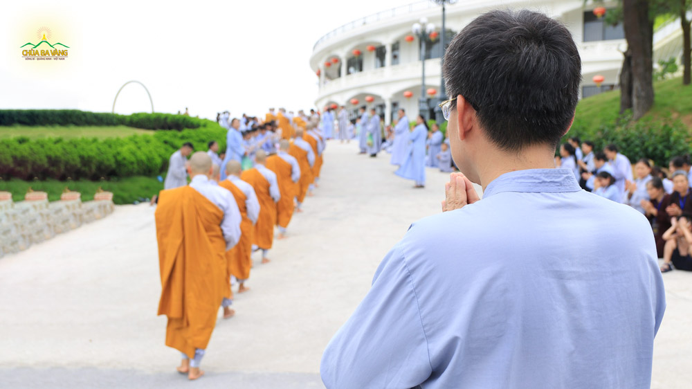 Phật tử Nguyễn Ngọc Công chắp tay thành kính khi chứng kiến Tăng đoàn trì bình khất thực tại khuôn viên chùa Ba Vàng
