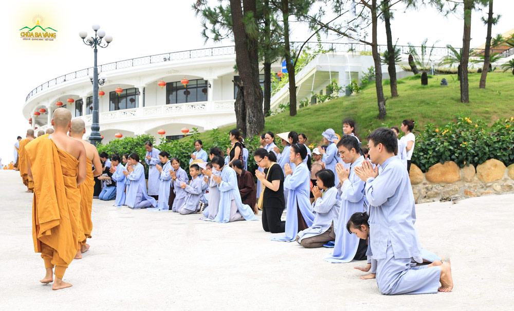 Phật tử Nguyễn Ngọc Công quỳ gối chắp tay trang nghiêm khi tham dự chương trình sớt bát cúng dường chư Tăng tại chùa Ba Vàng