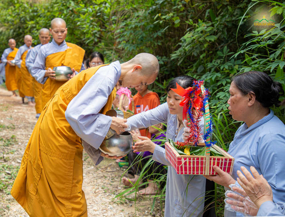 Phật tử cung kính dâng vật phẩm cúng dường vào bình bát của chư Ni