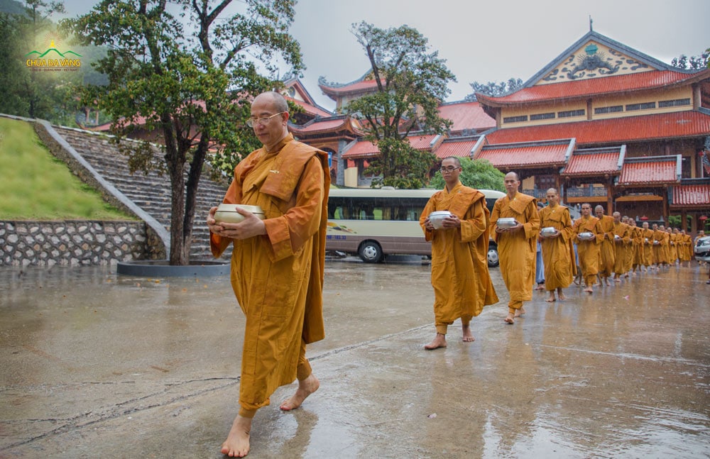 Hình ảnh Sư Phụ cùng Tăng đoàn an nhiên, tự tại chân trần ôm bình bát đi khất thực dưới mưa trong ngày sinh hoạt CLB Tuổi Trẻ Ba Vàng lần thứ 26