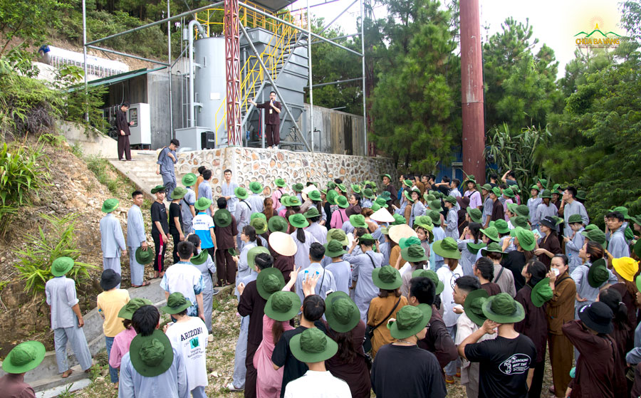 Thành viên Ban điều hành giới thiệu cho các bạn tình nguyện viên về nhà máy sản xuất nước của chùa