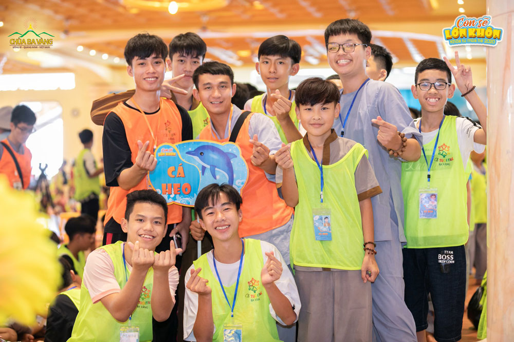 Các tình nguyện viên và khóa sinh nhóm Cá heo chụp ảnh cùng nhau tại nơi diễn ra buổi sinh hoạt chung của Khóa tu mùa hè