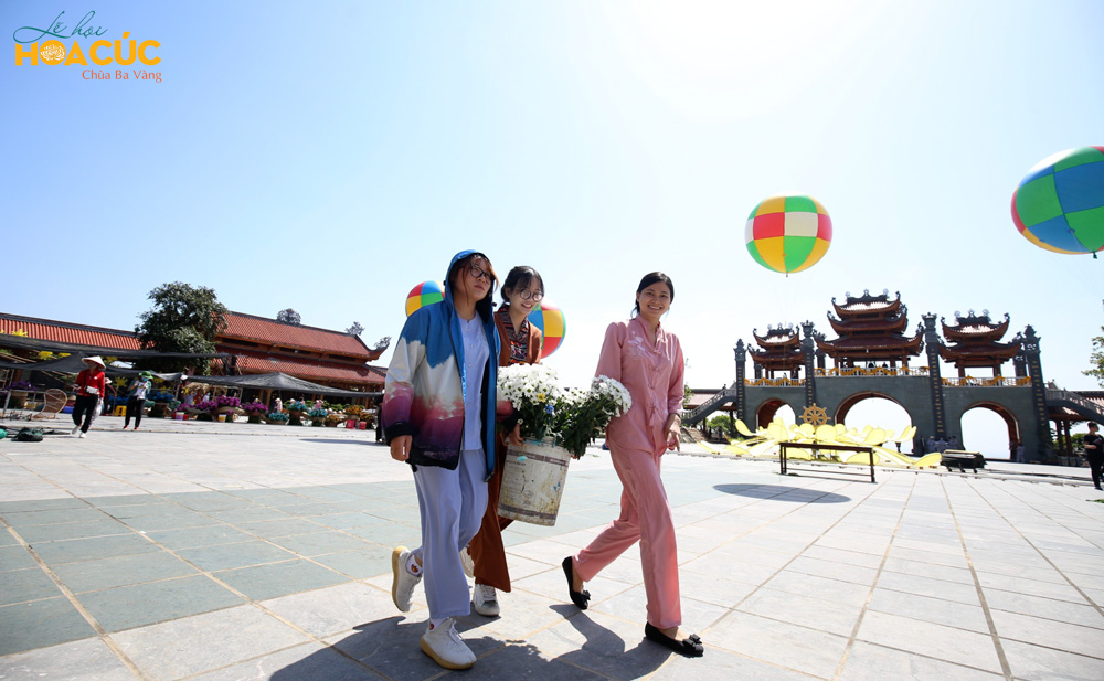Trong khung cảnh thơ mộng với trời xanh cùng những quả bóng bay rực rỡ, các Phật tử trẻ hân hoan chuẩn bị hoa cúc cho lễ hội