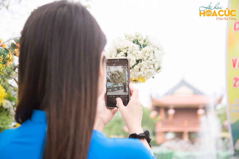 Bạn trẻ ghi lại hình ảnh một góc tiểu cảnh tại khu vực hồ Bán Nguyệt trong Lễ hội Hoa Cúc chùa Ba Vàng 2020 - Hướng về miền Trung thân yêu