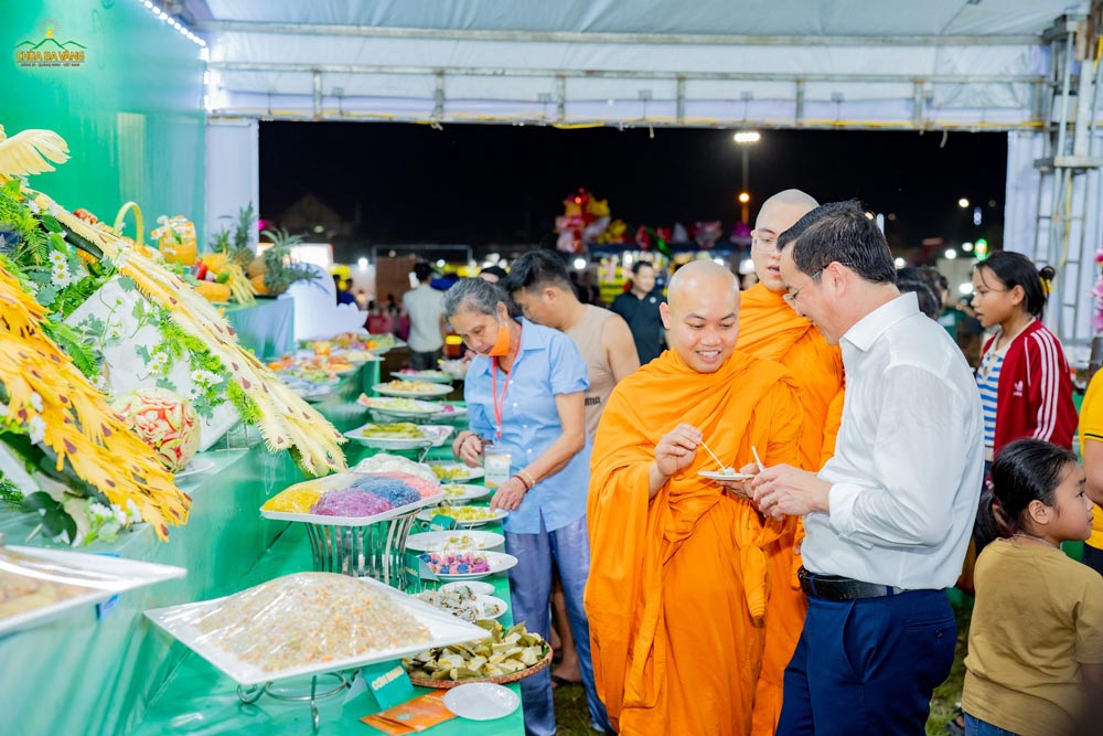 Chư Tăng chùa Ba Vàng đảm trách phận sự tại BTS GHPGVN huyện Minh Hóa giới thiệu đến ông Đinh Tiến Dũng món ăn chay tại gian hàng.