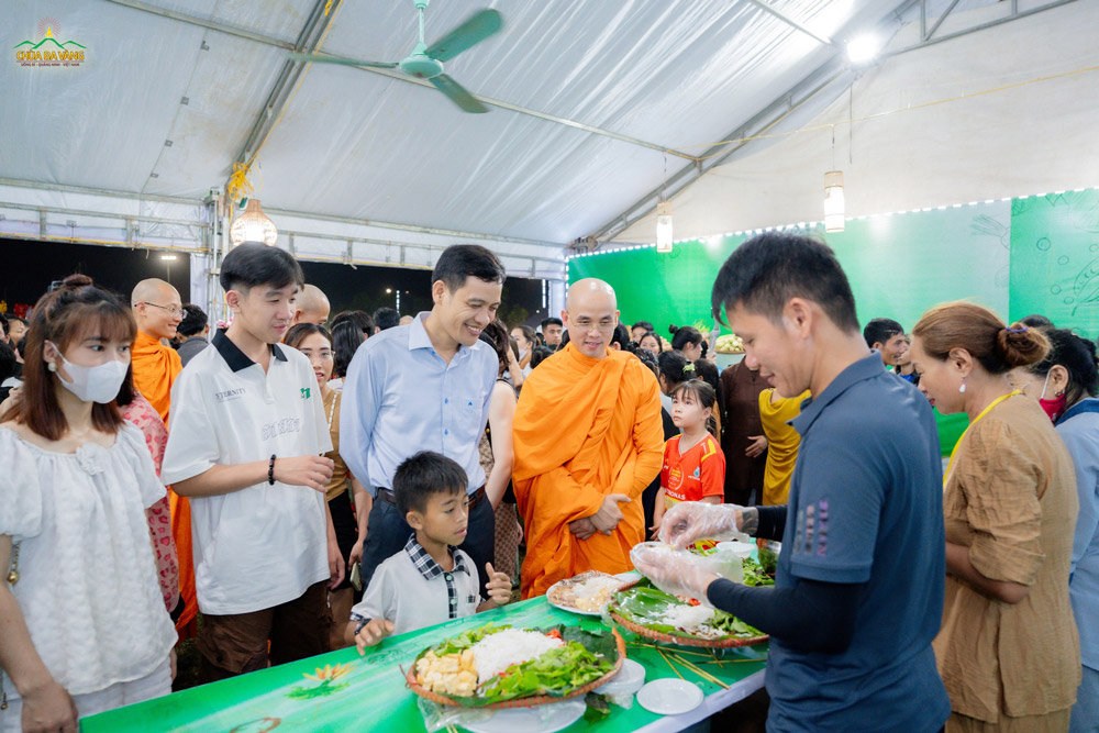 Ông Đinh Xuân Thông - Huyện uỷ viên, Bí thư xã Trung Hoá thăm quan gian hàng ẩm thực chay của BTS huyện Minh Hóa.