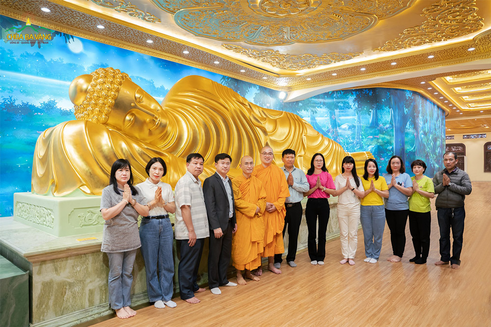 Ông Nguyễn Đức Tiệp - Hiệu trưởng Trường Đại học Hạ Long cùng các thầy cô giáo Trường Đại học Thủy Lợi chụp ảnh lưu niệm trước tôn tượng Đức Phật nhập Niết Bàn tại chùa Ba Vàng