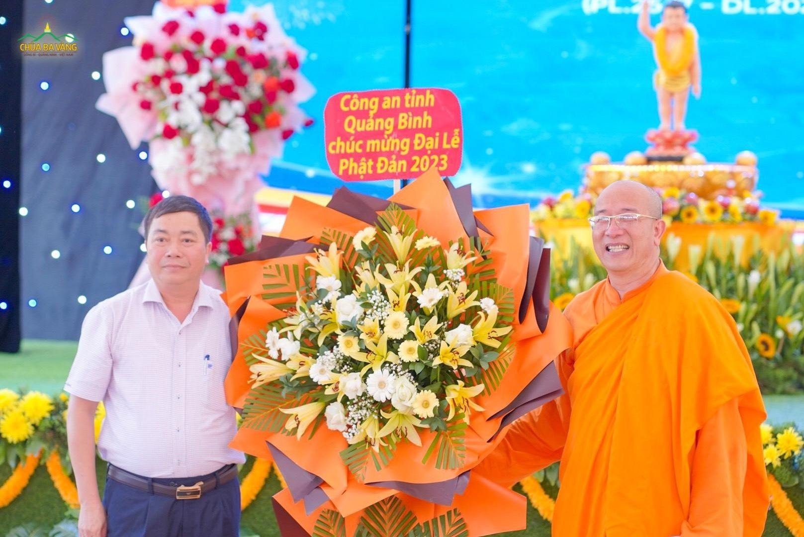 Thượng tá Trần Văn Sáng - Phó trưởng phòng an ninh nội địa Công an tỉnh Quảng Bình tặng hoa chúc mừng Đại lễ