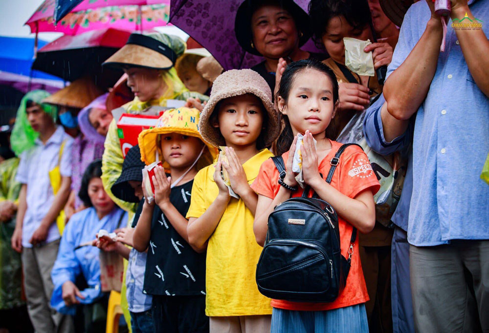 Các em nhỏ thành kính dâng phẩm vật cúng dường