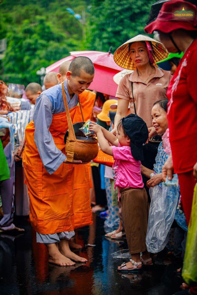Em nhỏ thành kính dâng vật thực cúng dường
