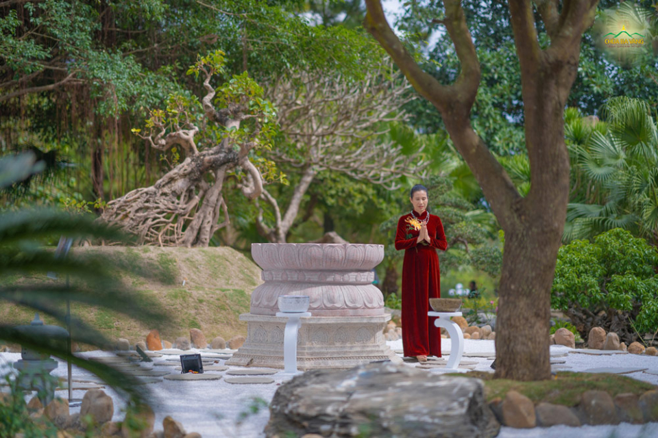 Phật tử Phạm Thị Yến nhiễu quanh khối đàn bàn chân Phật tại vườn thiền chùa Ba Vàng  