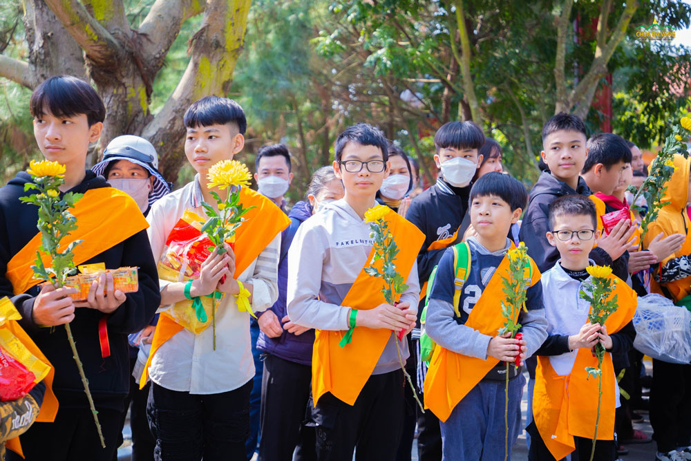 Các em nhỏ trong CLB La Hầu La đã chuẩn bị những bông hoa tươi để dâng lên cúng dường chư Tăng chùa Ba Vàng  