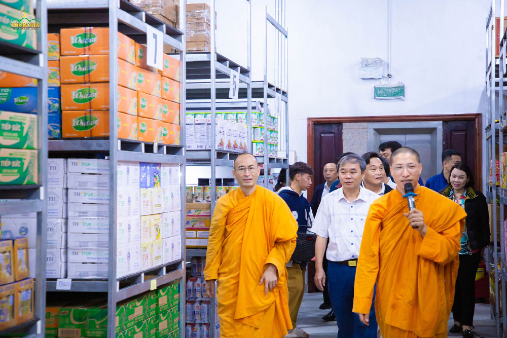 Chư Tăng dẫn đoàn Dân vận tỉnh Nghệ An tham quan nơi để lương thực tại khu bếp chùa Ba Vàng
