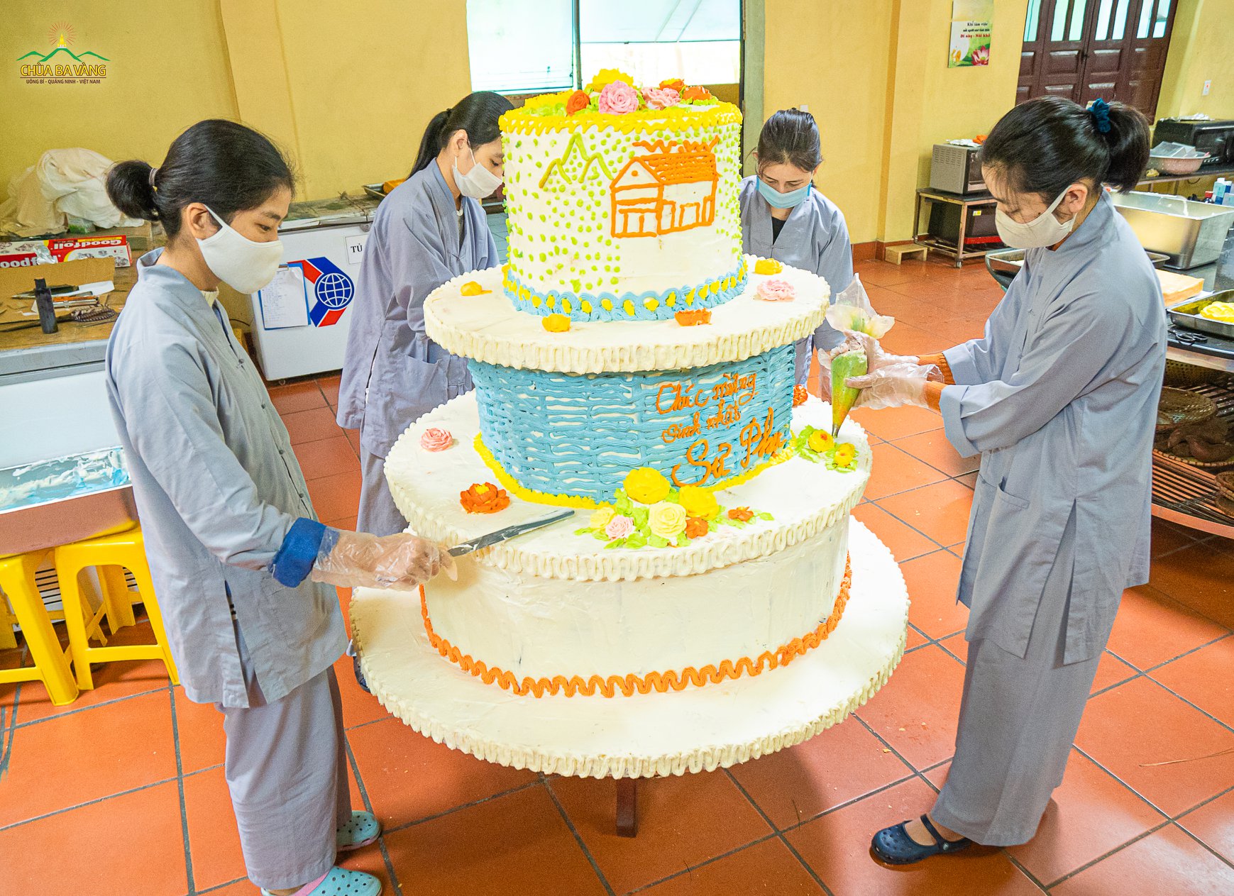 Các Phật tử đang hoàn thiện những công đoạn trang trí cuối cùng cho chiếc bánh sinh nhật
