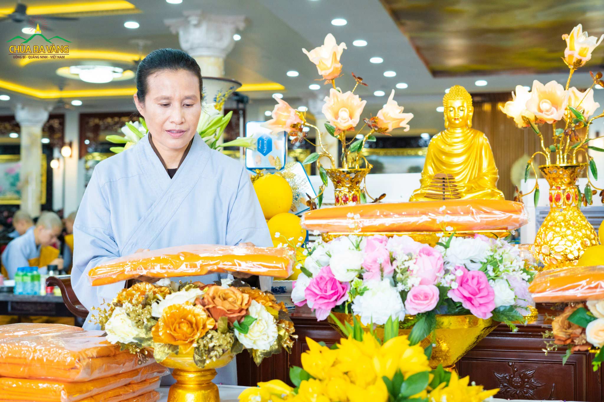 Phật tử Phạm Thị Yến (Tâm Chiếu Hoàn Quán) - Chủ nhiệm CLB Cúc Vàng chùa Ba Vàng dâng y cúng dường lên ban thờ Phật