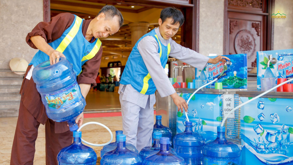 Tại khu vực Đại giảng đường, các Phật tử trong nhóm phục vụ nước đang tiếp thêm nước vào các bình để phục vụ cho các bạn khóa sinh