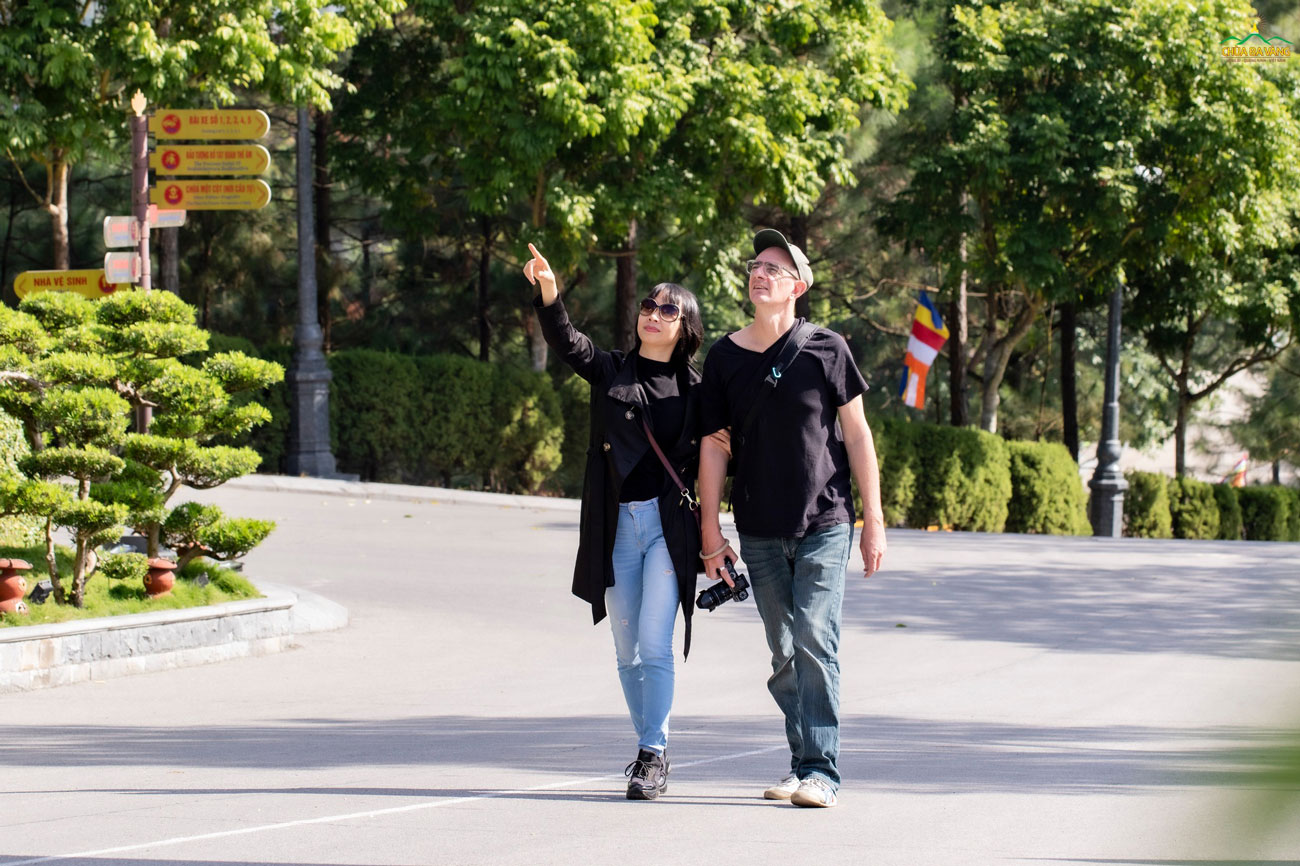 Nữ du khách người Việt giới thiệu cho người bạn nước ngoài về ngôi chùa