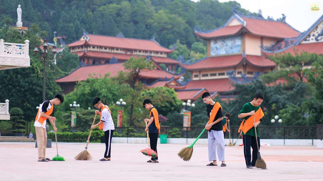 Các bạn khóa sinh chăm chỉ quét tại khu vực sân cụ Phật đản sinh.